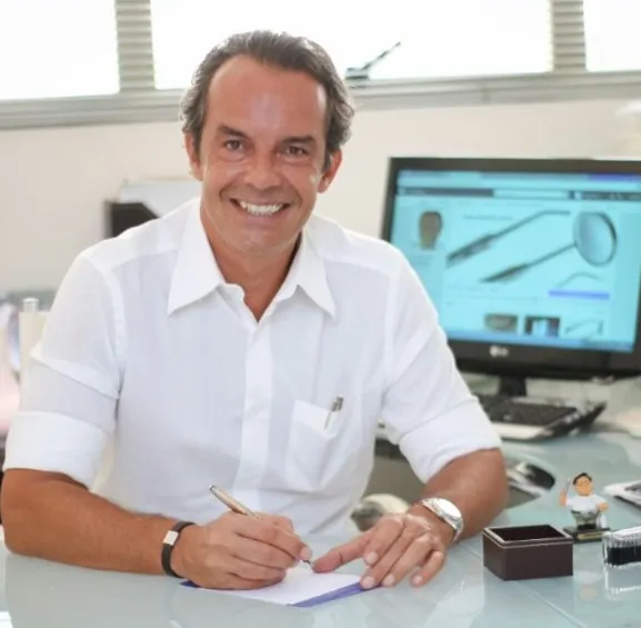 Dr. Marcelo Martins em sua mesa no consultório de Moema